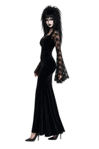 Woman wearing a black velvet dress with lace sleeves on a white background
