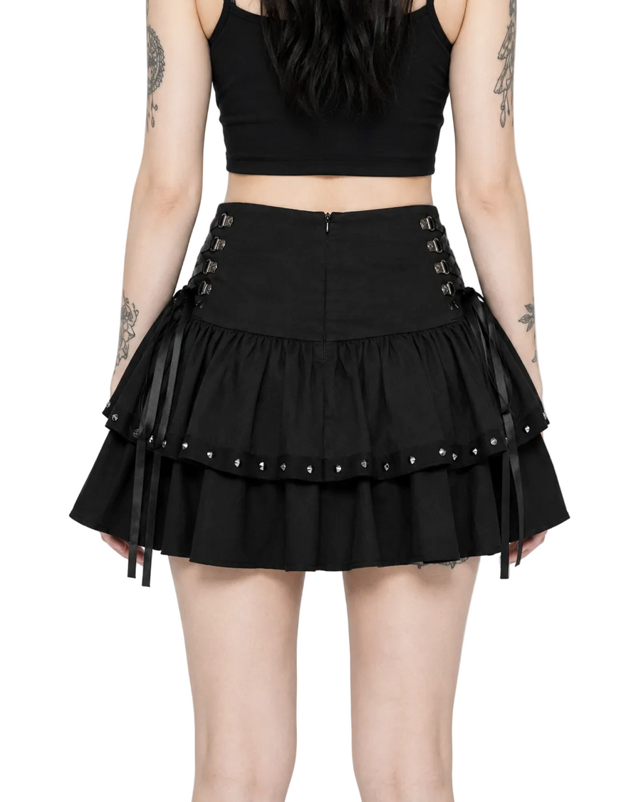 Person wearing a black skirt with lace-up details on a white background