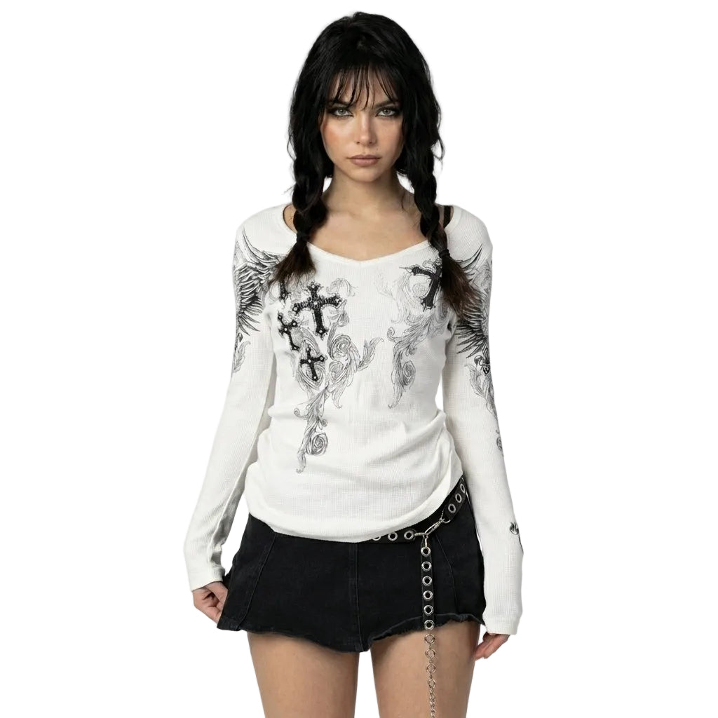 Woman wearing a white long-sleeve top with black floral patterns and a black skirt on a white background