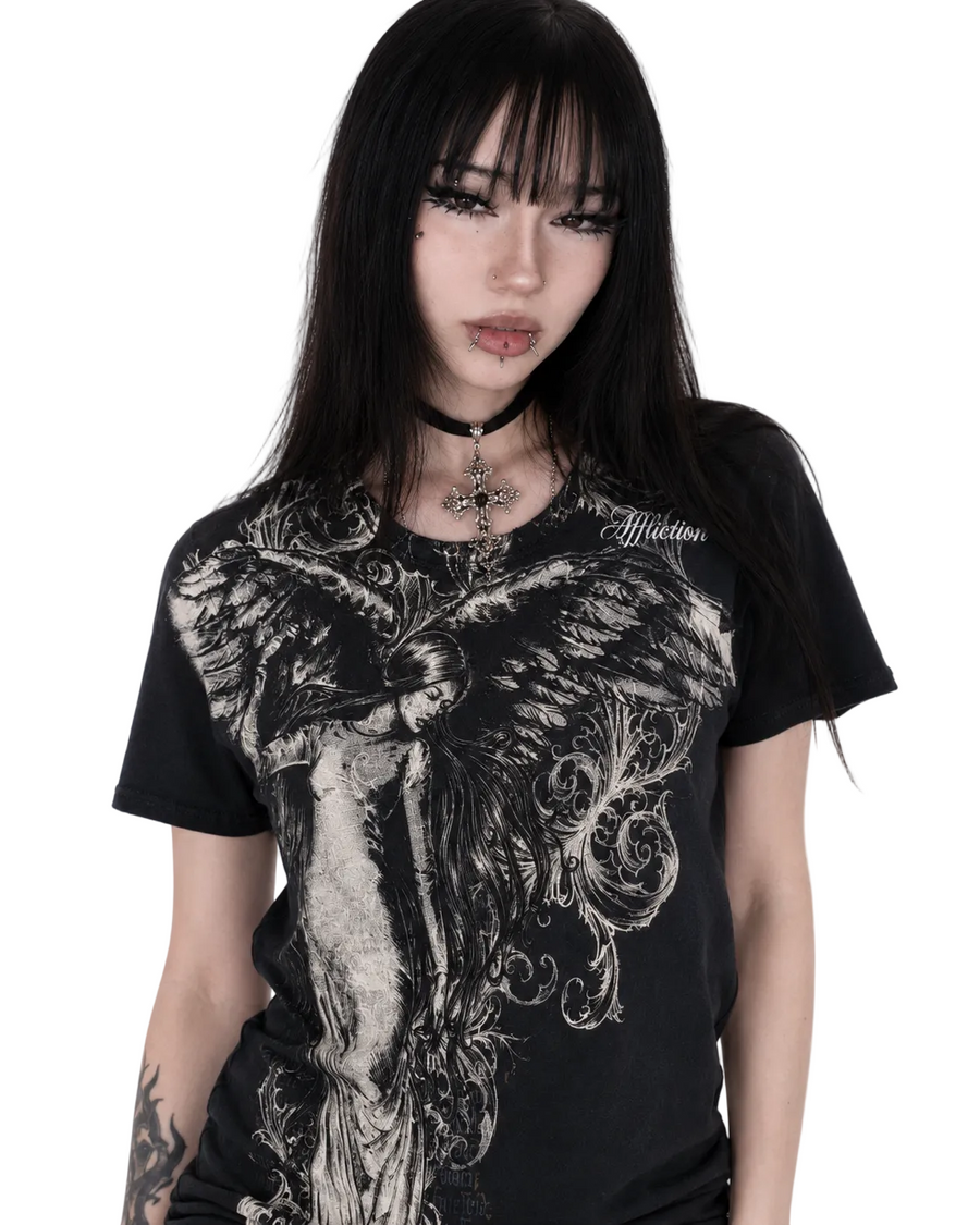 Person wearing a black t-shirt with intricate design and 'Affliction' branding.
