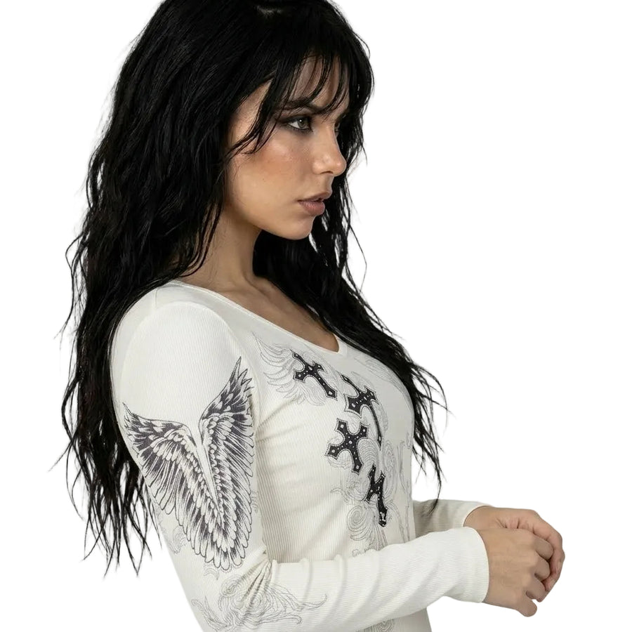 Woman wearing a white long-sleeve top with black designs on a white background